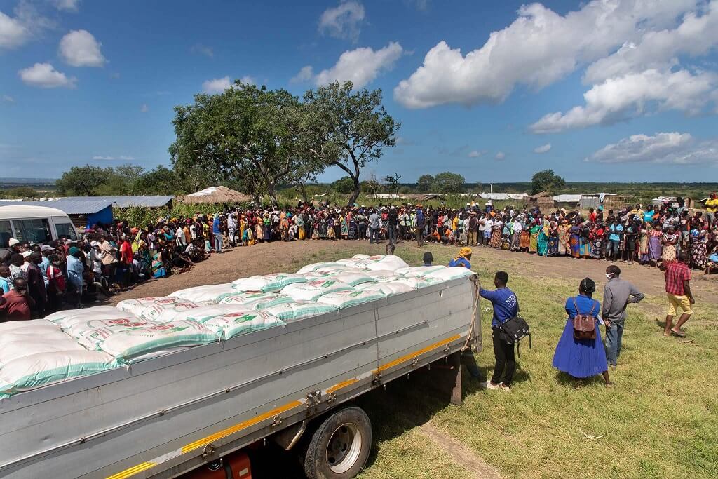 Large group of people awaiting aid from supply truck