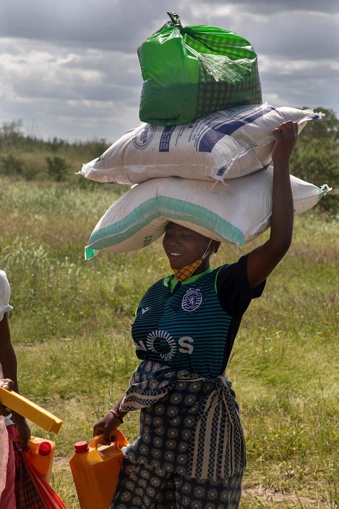 Woman carrying freshly recieved supplies from truck